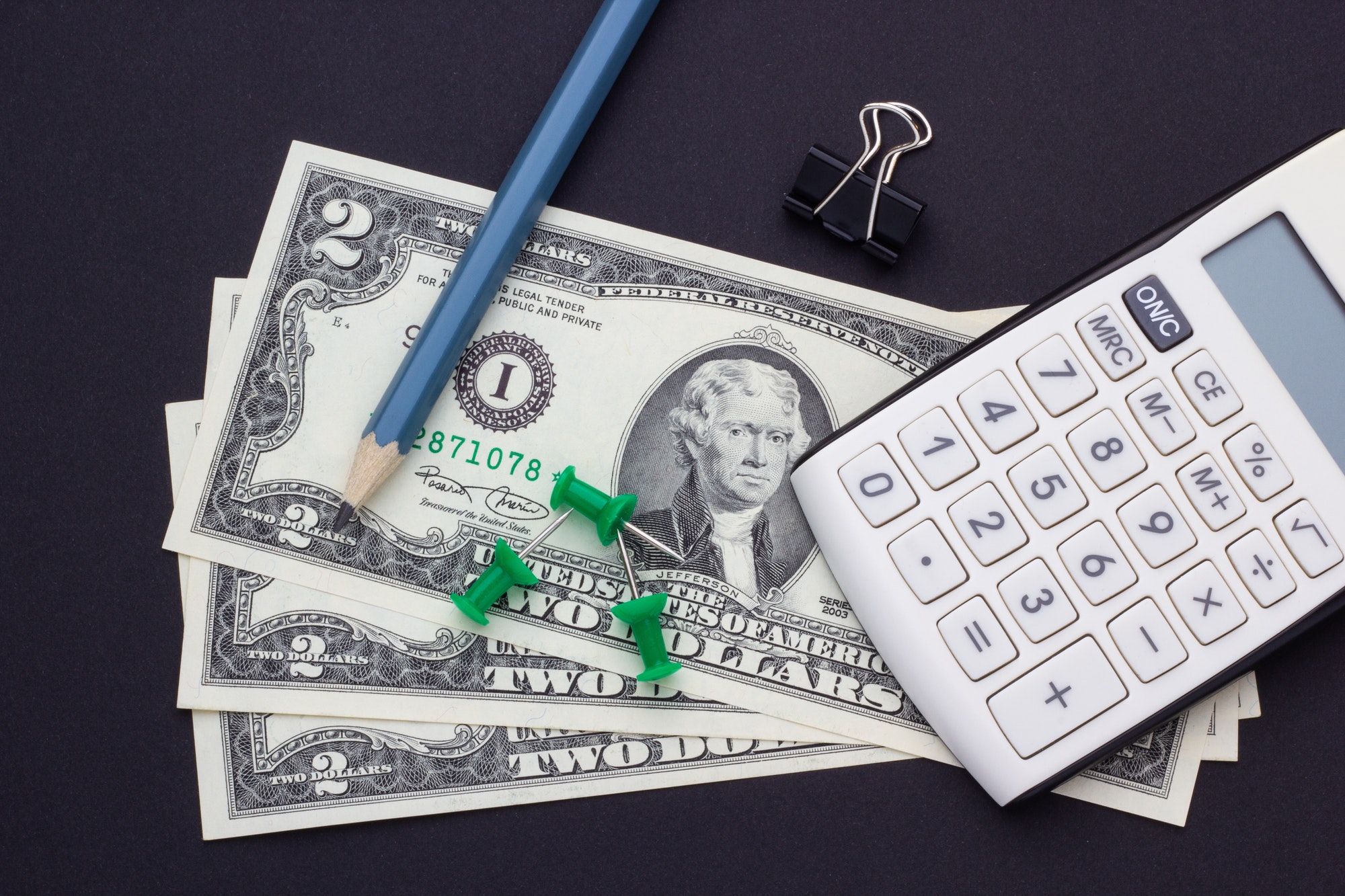 Calculator, pencil and office accessories on a black background